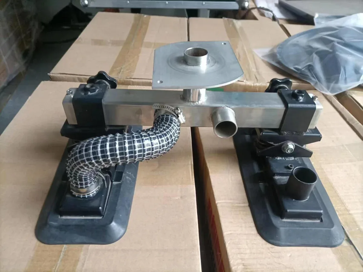 Cabezal de dos ventosas fotografiado antes de completar todas las conexiones de manguera. Permite identificar conjuntamente la interfaz de montaje, las conexiones individuales y la posición de las ventosas; no muestra un conjunto listo para funcionar.